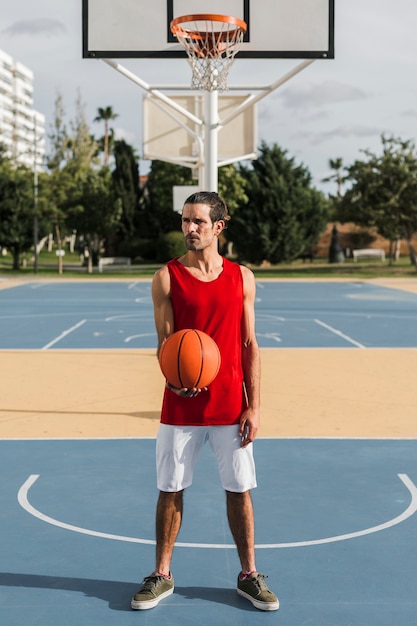 Plano completo del niño con pelota de baloncesto