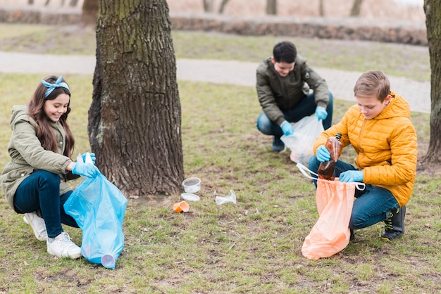 Plano completo de niños con bolsas de plástico