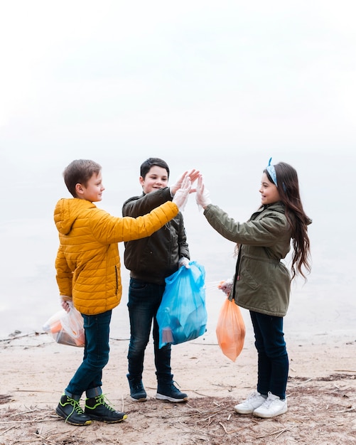 Plano completo de niños con bolsas de plástico