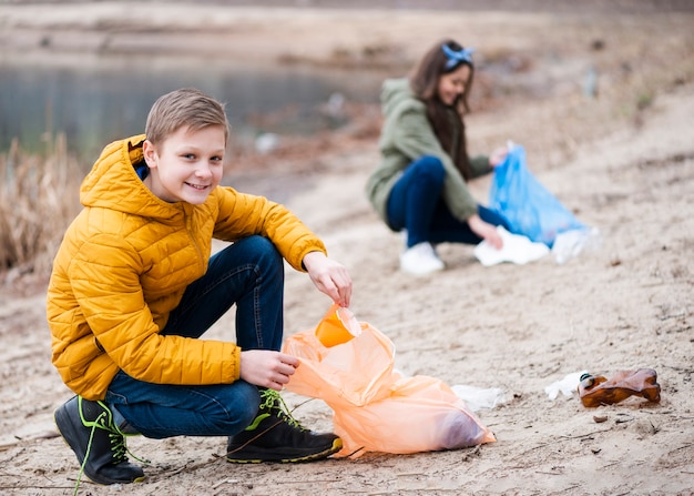 Foto gratuita plano completo de niños limpiando el suelo