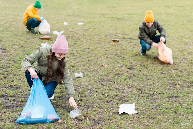 Plano completo de niños limpiando el suelo