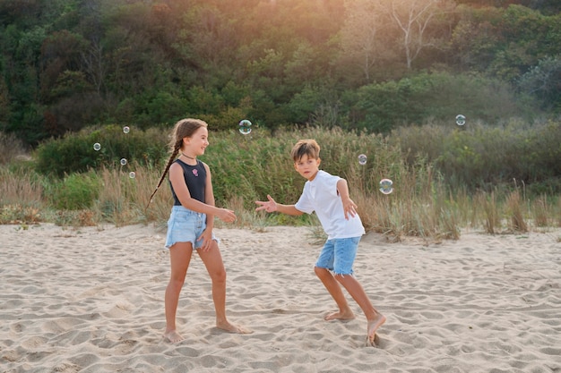 Plano completo de niños pequeños divirtiéndose en la playa.