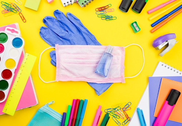 Plano de elementos esenciales de la escuela con guantes y lápices.