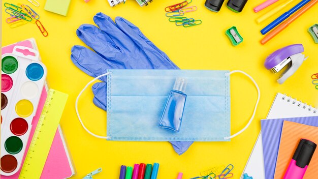 Plano de elementos esenciales de la escuela con guantes y mascarilla médica.