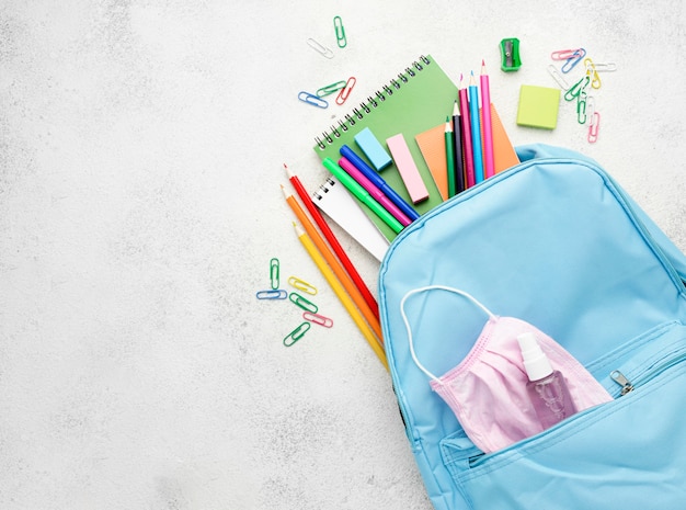 Foto gratuita plano de elementos esenciales de la escuela con mochila