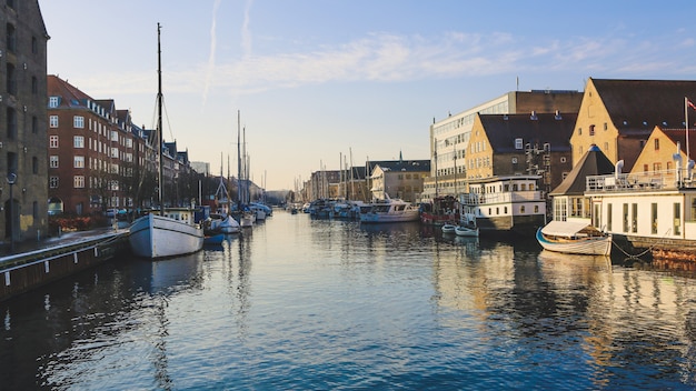 Plano general de barcos en el cuerpo de agua cerca de edificios en Christianshavn, Copenhague, Dinamarca