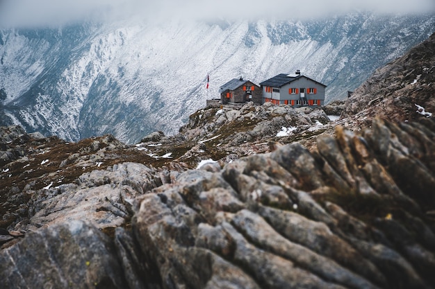 Plano general de una casa aislada en las montañas cubiertas de nieve en Capanna Cadlino