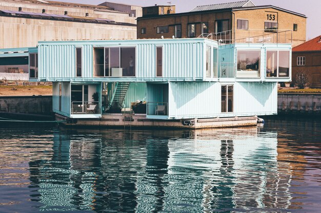 Plano general de una casa azul claro en un muelle en el cuerpo de agua