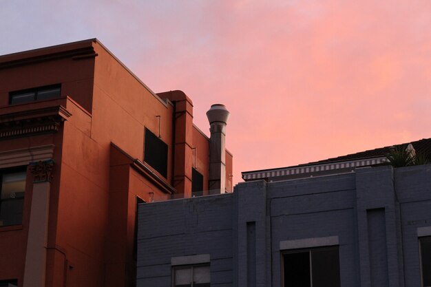 Plano general de casas marrones y grises bajo un cielo rosado