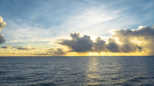 Plano general de un mar y un cielo nublado al sol grosero