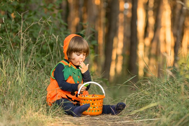 Plano general de niño lindo en traje de calabaza