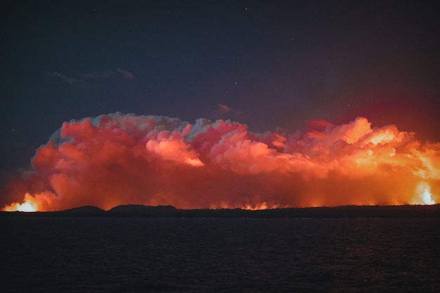 Plano general de nubes naranjas en un cielo nocturno oscuro