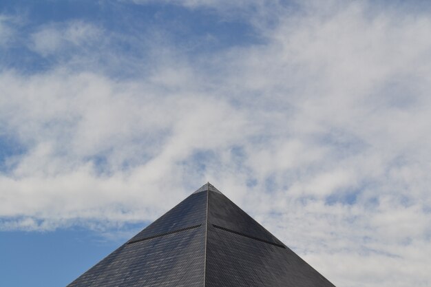 Plano general de una pirámide egipcia gris en Las Vegas, California, bajo un cielo azul con nubes