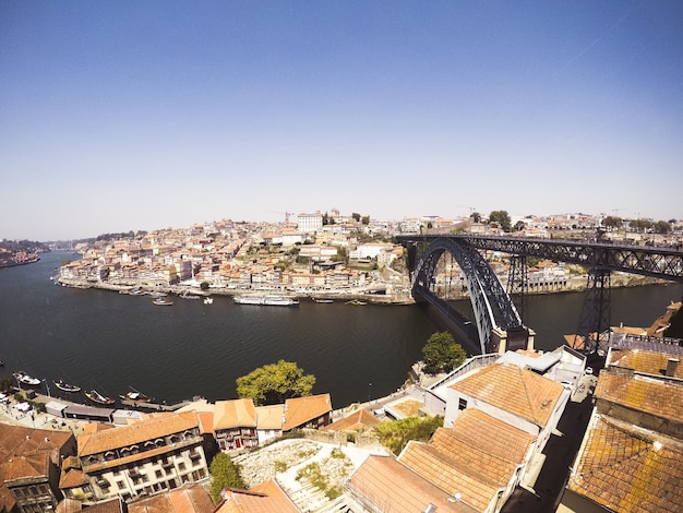 Plano general de un puente de arco negro en el cuerpo de agua que conecta ciudades a orillas del lago