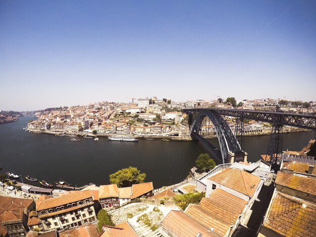 Plano general de un puente de arco negro en el cuerpo de agua que conecta ciudades a orillas del lago