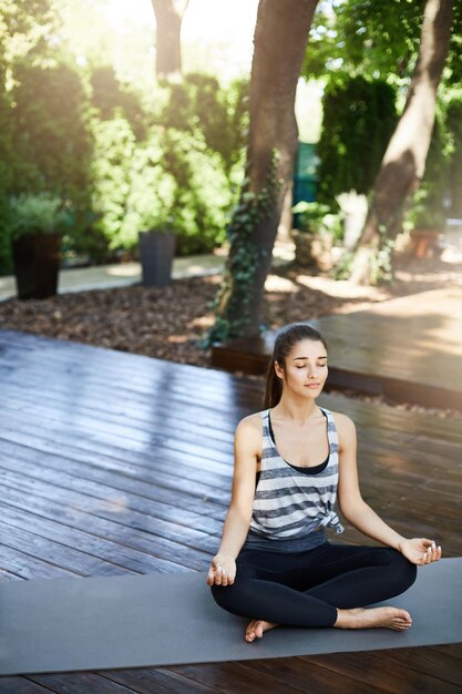 Plano general de yogui femenina meditando en un moderno templo de yoga urbano Espacio negativo