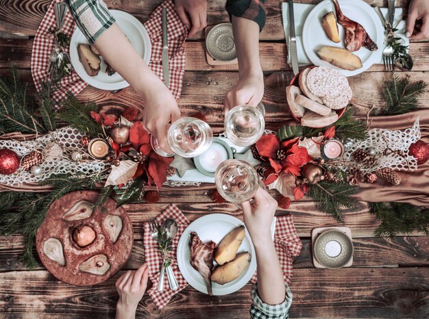 Plano de manos de amigos comiendo y bebiendo juntos. Vista superior de personas que tienen fiesta, reunión, celebrando juntos en la mesa rústica de madera