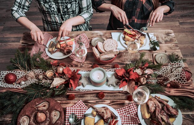 Plano de manos de amigos comiendo y bebiendo juntos. Vista superior de personas que tienen fiesta, reunión, celebrando juntos en la mesa rústica de madera