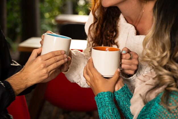 Plano medio de amigo con tazas de café