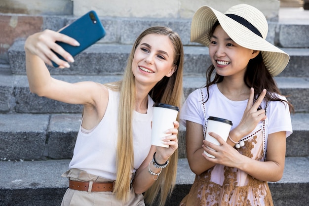 Foto gratuita plano medio de amigos diversos que toman selfie