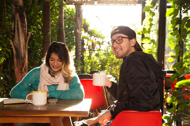 Foto gratuita plano medio de amigos en la terraza de la cafetería