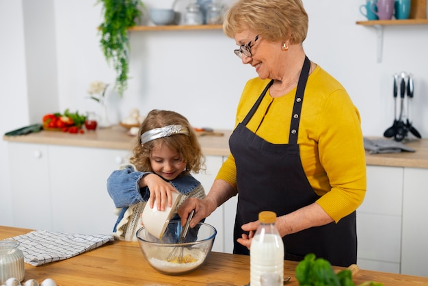 Foto gratuita plano medio anciana y niña en la cocina