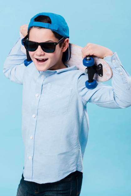 Plano medio del chico moderno con patineta y gafas de sol