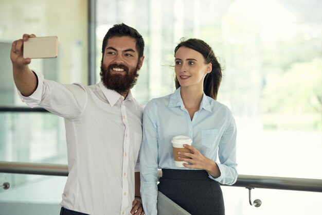 Plano medio de colegas tomando una selfie