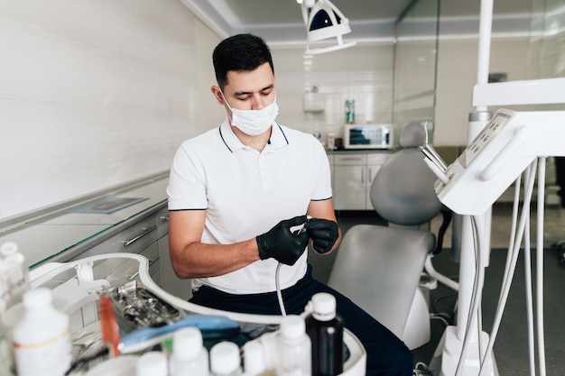 Plano medio del dentista revisando el equipo quirúrgico