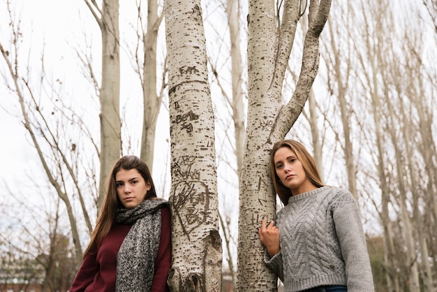 Plano medio de dos hermosas mujeres jóvenes en el parque