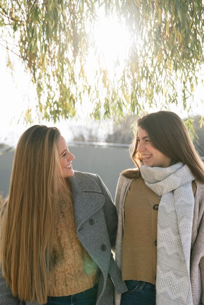 Plano medio de dos mujeres hablando en el parque.