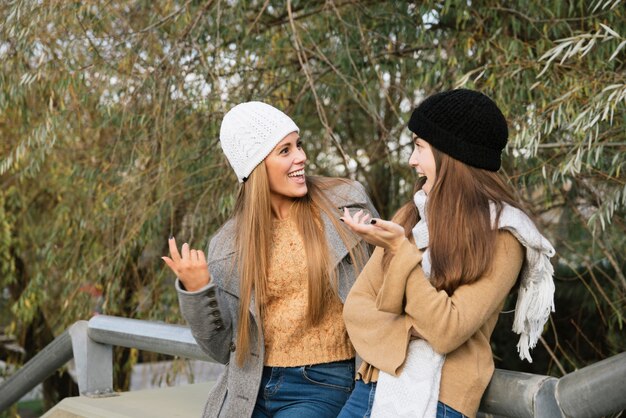 Plano medio de dos mujeres hablando en el parque.