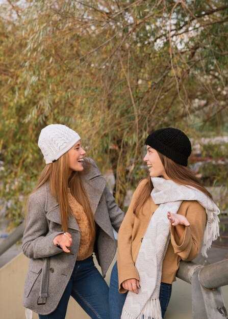 Plano medio de dos mujeres hablando en el parque.