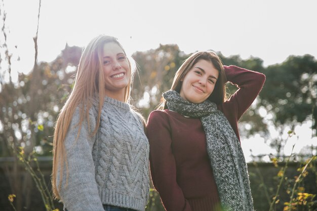 Plano medio de dos mujeres posando en el parque.