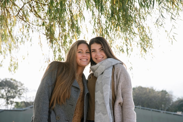 Plano medio de dos mujeres sonrientes en el parque