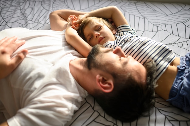 Plano medio durmiendo padre e hijo
