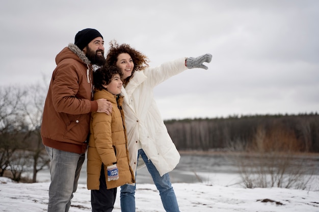 Plano medio familia feliz al aire libre