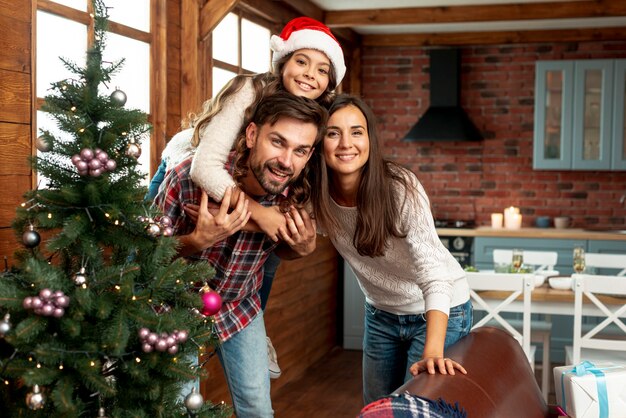 Plano medio felices padres e hijos posando en interiores