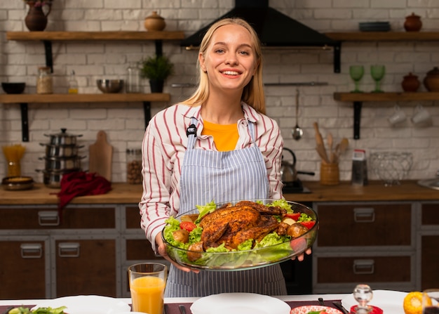 Foto gratuita plano medio de feliz mujer sosteniendo un pavo