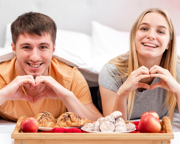 Foto gratuita plano medio gesto de mano en forma de pareja feliz corazón