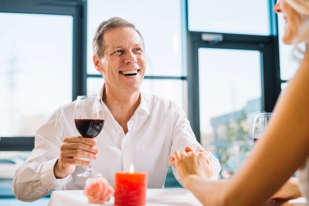 Plano medio del hombre bebiendo vino en la cena