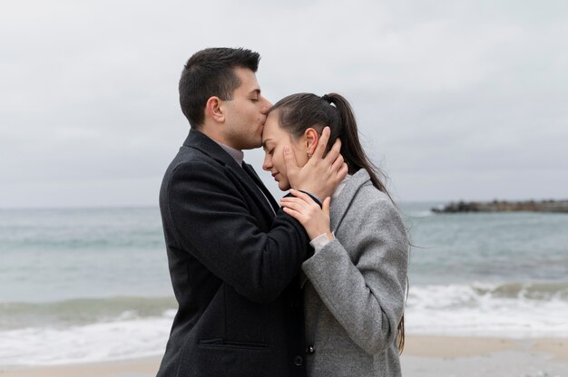 Plano medio hombre besando la frente de la mujer