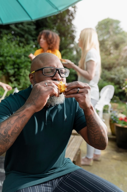 Plano medio hombre comiendo maíz