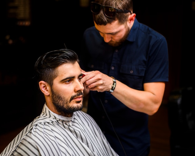 Foto gratuita plano medio del hombre cortándose el pelo