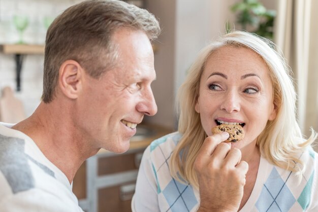 Plano medio hombre feliz alimentando a su pareja