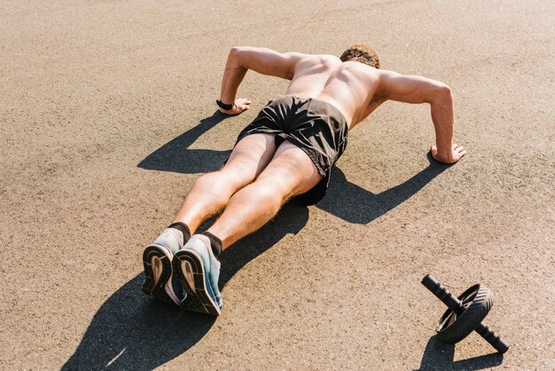 Plano medio del hombre haciendo flexiones.