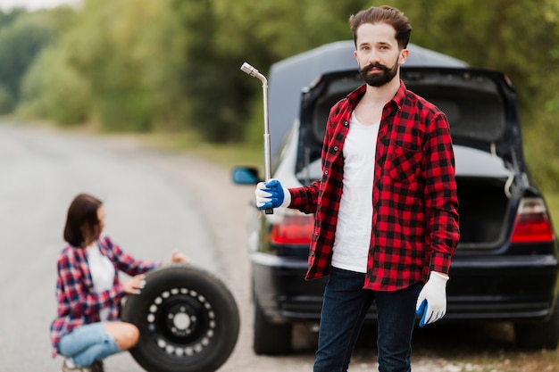 Foto gratuita plano medio del hombre con llave de neumático