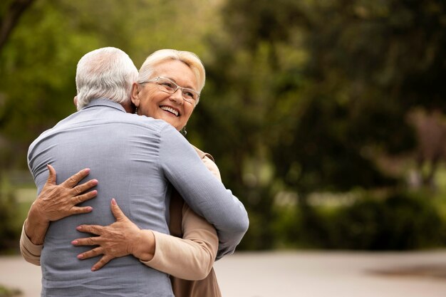 Plano medio, hombre y mujer, abrazar, aire libre