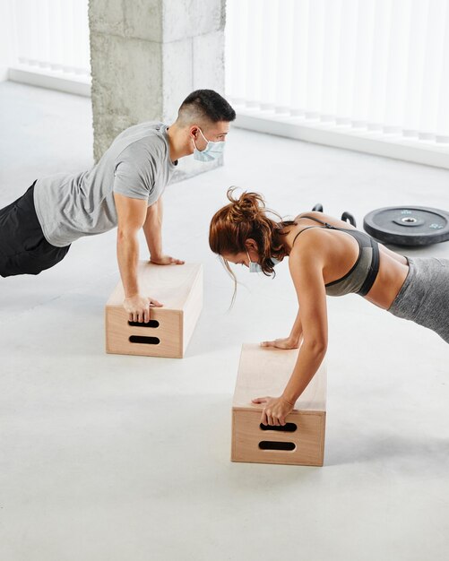 Plano medio hombre y mujer haciendo flexiones