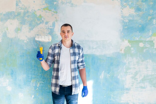 Plano medio del hombre que sostiene un rodillo de pintura